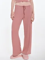 Pantalón de dormir de corte recto y holgado, confeccionado en tela de micro polar con textura acanalada. Presenta cintura elástica con cordón ajustable y bolsillos laterales.
