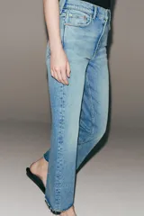 Jeans cropped flare de tiro medio color celeste, confeccionados en denim con efecto lavado. Presentan diseño de cinco bolsillos, trabillas para cinto, raya planchada al frente y bajo desflecado con terminación evasé. Cuenta con cierre frontal de cremallera y botón metálico.