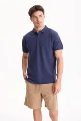 Chomba de piqué color blanco, con cuello polo y cierre frontal con tres botones.