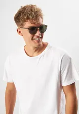 Lentes de sol redondos con montura gris translúcido y lentes verdes. Fabricados con acetato biodegradable y lentes de PMMA reciclado.