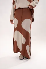 Pollera larga marrón con estampado de manchas grandes color crema, corte recto y abertura lateral.