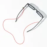 Correa para lentes roja con cuentas de cristal y terminales doradas.
