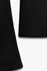 Camiseta de cuello redondo y manga larga con terminación acampanada en los puños, de corte ajustado al cuerpo.