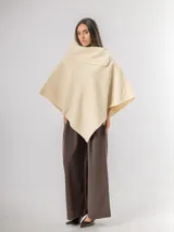 Poncho de tejido texturizado en color marrón chocolate, con cuello amplio y diseño asimétrico.