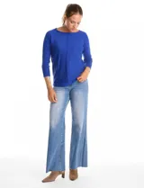 Buzo de tejido fino con manga tres cuartos y puños acanalados. Presenta un pespunte vertical en el centro del frente y detalle de botones en la espalda.