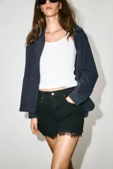 Shorts de denim negro de tiro alto con cinco bolsillos, cierre frontal con cremallera y botón, y detalle de encaje en el bajo.