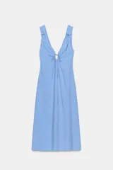 Vestido midi confeccionado en mezcla de viscosa con estampado de rayas verticales en celeste y blanco. Posee escote en pico con abertura ajustable mediante lazada en el pecho, tirantes anchos y cierre lateral con cremallera oculta. El diseño cuenta con aberturas en el bajo frontal y posterior.