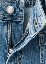 Jeans wide leg de tiro alto en tejido denim azul, con bolsillos de parche delanteros, trabillas para cinto y cierre frontal con cremallera y botón.