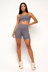 Conjunto deportivo de alto rendimiento compuesto por un top de diseño nadador y un short tipo biker de tiro alto. Ambas prendas cuentan con múltiples bolsillos funcionales y detalles reflectivos para mayor visibilidad. Confeccionado en tejido técnico de poliamida y elastano con protección UV50+, alta respirabilidad y secado rápido.