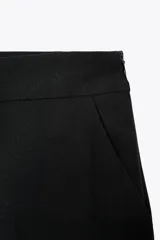 Pantalón culotte de tiro alto con pernera ancha y corta. Presenta bolsillos delanteros y cierre lateral con cremallera oculta.