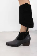 Botineta de cuero negro mate con inserciones de gamuza en el talón, punta cuadrada y tacón de bloque. Cuenta con cierre lateral interno.