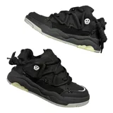 Zapatillas negras de estilo skate, con cordones gruesos y detalles en los costados.