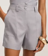 Short sastre de cintura alta, color gris, de corte recto y confeccionado en tejido de crepé. Presenta doble trabilla en la cintura y bolsillos simulados.