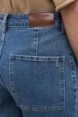 Jean culotte de corte ancho y tiro medio, en tono azul medio, con bolsillos aplicados en el frente.
