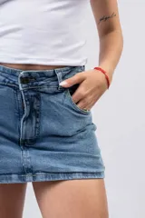 Short pollera de denim en lavado azul medio clásico, con diseño de mini falda en el frente y short incorporado.