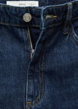 Jeans tiro alto wide leg de color azul, con diseño de cinco bolsillos, presillas para cinturón y cierre frontal con cremallera y botón.