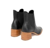 Botín tipo Chelsea de cuero negro con textura floater, paneles laterales elásticos y tacón de bloque en madera.