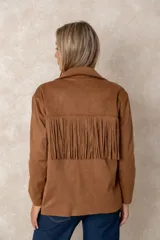 Chaqueta de gamuza sintética color marrón, con diseño de flecos en el pecho y la espalda. Presenta cierre frontal con botones, cuello camisero y bolsillos cuadrados frontales.
