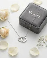 Collar de acero con cadena fina y dos dijes entrelazados, uno en forma de corazón y otro circular.