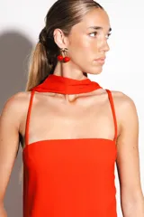 Vestido largo negro confeccionado en crepé y gasa, de corte al cuerpo con escote recto, tiritas finas y falda larga semitransparente con tajo lateral pronunciado. Incluye accesorio tipo corbatín a juego.