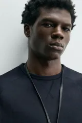 Camiseta de manga larga con cuello redondo, confeccionada en algodón compacto y pesado, con diseño de corte relajado y costuras decorativas en el cuello.