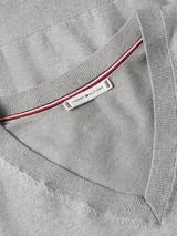 Sweater de punto Tommy Hilfiger, color gris, con cuello en V y manga larga. Presenta un diseño liso con el logo de la marca bordado en el pecho.