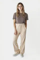 Pantalón de tiro alto con pierna ancha, cintura elástica con cordón ajustable y bolsillos laterales.