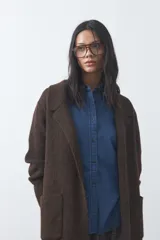 Cardigan de tejido de punto gris, con silueta larga, frente abierto, solapas clásicas y bolsillos aplicados en los laterales.