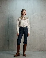 Camisa de manga larga con diseño de rayas verticales, confeccionada en algodón. Presenta un canesú superior en lana con estampado de cuadros en tonos tierra, cuello alto con volados y cierre frontal con botones.