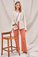 Cardigan color salmón de algodón y elastano, con solapa y lazo ajustable en la cintura.