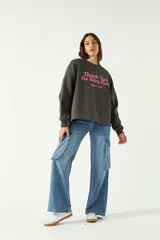 Buzo gris oscuro de algodón y poliéster con calce amplio y estampa frontal en color rosa con relieve.