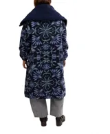 Tapado largo de polar con estampado floral en tonos azules, cuello de sherpa azul marino y cierre con botones a presión.