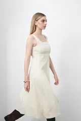 Vestido midi sin mangas de color azul oscuro, con escote cuadrado y silueta evasé. Presenta costuras a contratono en color blanco que recorren verticalmente el diseño, aportando estructura y un detalle gráfico. Confeccionado en tejido con cuerpo y caída firme.