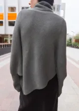 Jersey gris de punto con cuello vuelto, diseño oversize de manga larga y silueta asimétrica.