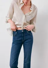Jeans de denim azul oscuro con diseño flare, tiro alto, trabillas y cinco bolsillos.