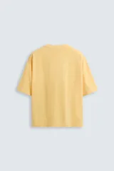 Camiseta gris de corte cuadrado y holgado, con cuello redondo y mangas cortas.