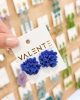 Aros tipo caravanas con diseño de flor en relieve, color azul intenso, con cierre de perno.