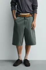 Bermuda tipo jorts de algodón color verde oscuro, con corte relajado y tiro medio. Presenta bolsillos frontales y bolsillos traseros de plastrón.