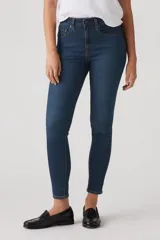 Jean skinny de tiro alto color azul oscuro, con cierre de botón y cremallera, y bolsillos delanteros y traseros.