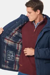 Campera color marrón con capucha desmontable, cierre frontal con cremallera y botones a presión, múltiples bolsillos con solapa y puños ajustables con botones.