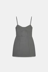 Vestido corto de corte ajustado con escote tipo bustier y tirantes finos. Presenta costuras verticales que definen la silueta y cierre posterior con cremallera oculta.
