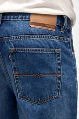 Jean de corte tapered, holgado en la cadera y levemente ajustado hacia los tobillos, con tiro medio y lavado azul clásico.