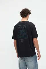Remera de manga corta color beige, confeccionada en jersey de algodón con textura suave y calce relaxed. Presenta costuras a contratono en la espalda y un diseño estampado en la parte posterior con ilustraciones de estilo lineal y frases manuscritas.