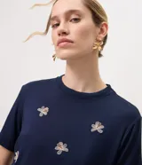 Remera de viscosa azul marino con cuello redondo, mangas cortas y bordados florales repartidos en el frente.