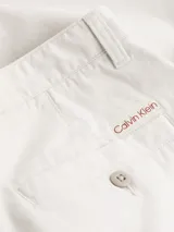 Pantalón cropped holgado color crema, confeccionado en sarga de algodón regenerativo. Presenta cintura plisada, cierre mediante botón y cremallera, bolsillos de hendidura y bolsillos traseros ribeteados.