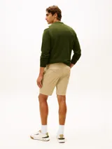 Pantalón chino corto Tommy Hilfiger de corte regular y pierna recta, confeccionado en mezcla de algodón orgánico, algodón y elastano. Cuenta con dos bolsillos delanteros en diagonal y dos bolsillos traseros de ojal con botón.