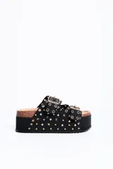 Sandalia plataforma color negro, con doble tira ancha con hebillas y tachas doradas, suela de corcho y plataforma alta texturizada.