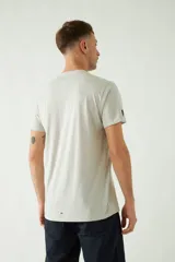 Remera de manga corta color gris claro con cuello redondo y estampado de tres fotos en blanco y negro en el frente.