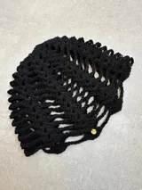 Casquete tejido a crochet en hilo de algodón color marrón, con diseño de red calada.