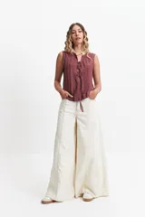 Blusa color borgoña sin mangas con lazo frontal y textura liviana.